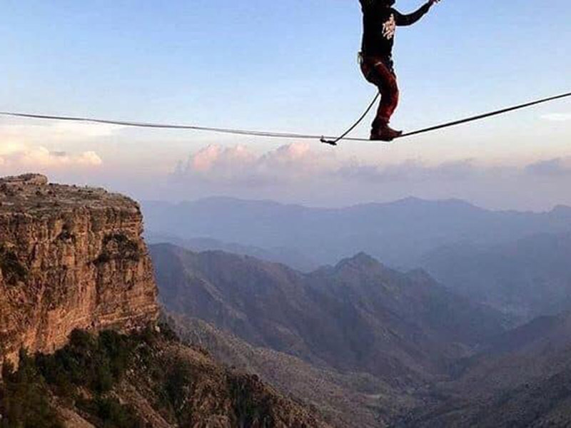 فيديو.. مغامران سعودي وأمريكي يسيران على حبل معلق بين حافتي جبل في أبها